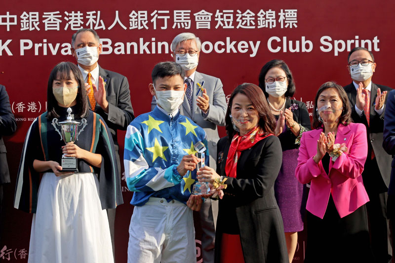 Ms. Mary Lo, General Manager, Personal Digital Banking Product Department of Bank of China (Hong Kong) Limited, presents a crystal trophy to winning jockey Jerry Chau.