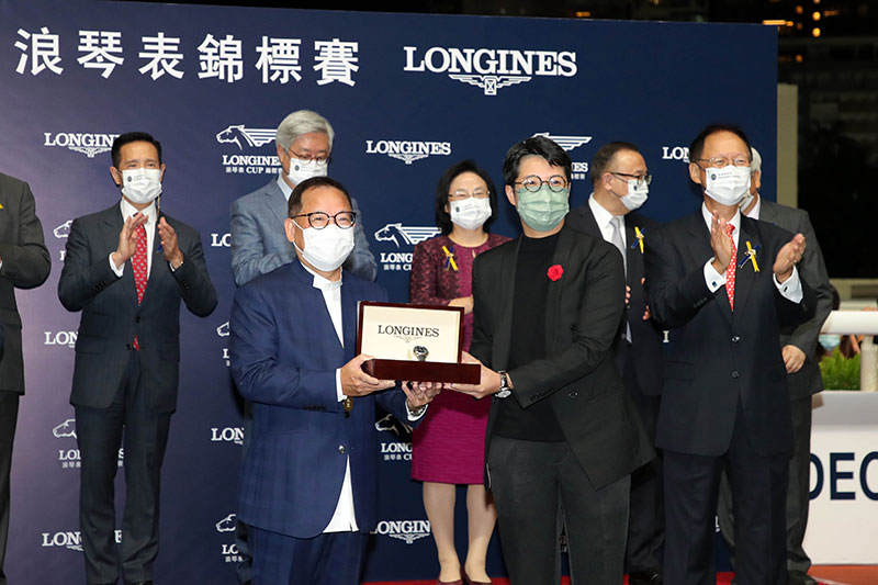 Ms Ida Chan, Marketing & PR Manager of LONGINES Hong Kong, presents models from The LONGINES Master Collection to owner representative Mr Cheung Ming Man, trainer David Hayes and jockey Zac Purton, winning connections of Harmony N Blessed.