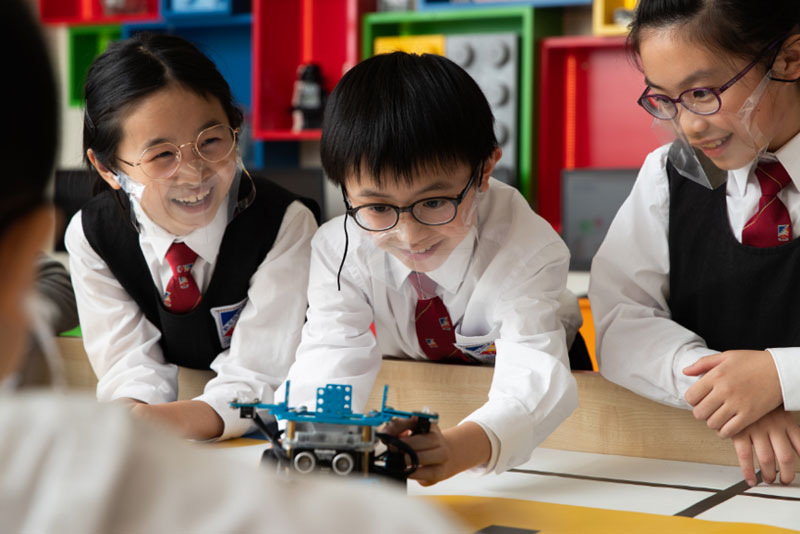 Anson Yeung (middle), a student at King's College Old Boys' Association Primary School No.2, says he’s enjoyed working with his schoolmates to solve various problems with coding skills in the CoolThink programme.