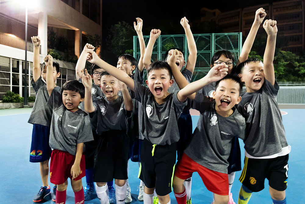 Asher (third from right, front row), 9, loves going to children’s football training under the Jockey Club Community Football for Hope project. He says he can see himself playing football for many years to come.