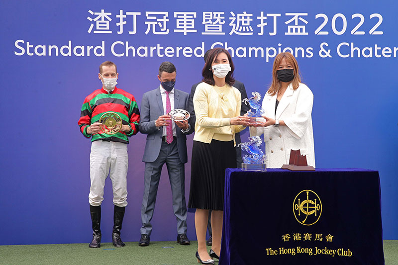 Mary Huen, Chief Executive Officer, Hong Kong, Standard Chartered Bank, presents souvenirs to Mrs Cheung and jockey Blake Shinn.