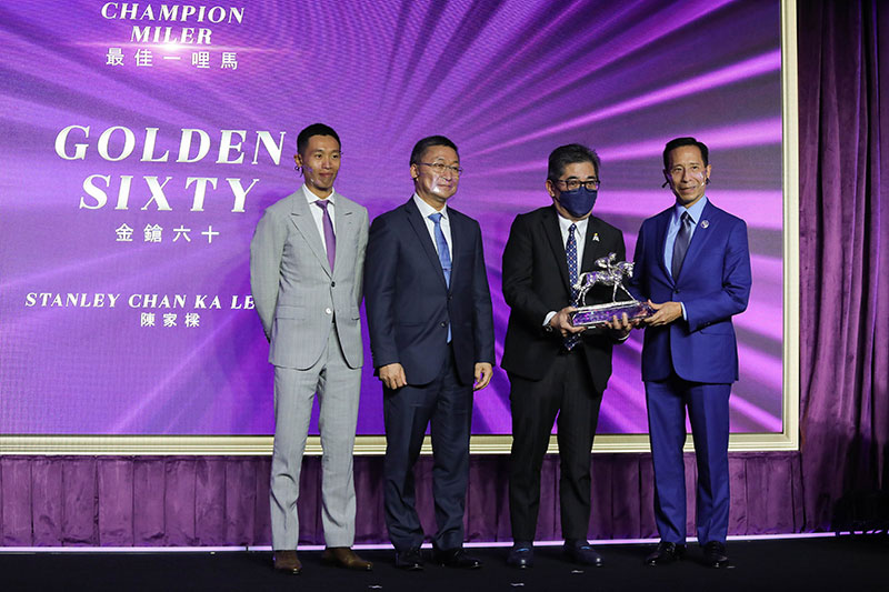 Mr Richard Tang, Steward of The Hong Kong Jockey Club, presents the Champion Miler trophy to Mr Stanley Chan Ka Leung, owner of Golden Sixty. The owner is accompanied by trainer Francis Lui and jockey Vincent Ho.