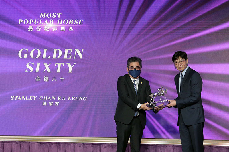Dr Henry Chan, Steward of The Hong Kong Jockey Club, presents the Most Popular Horse of the Year trophy to Mr Stanley Chan Ka Leung, owner of Golden Sixty.
