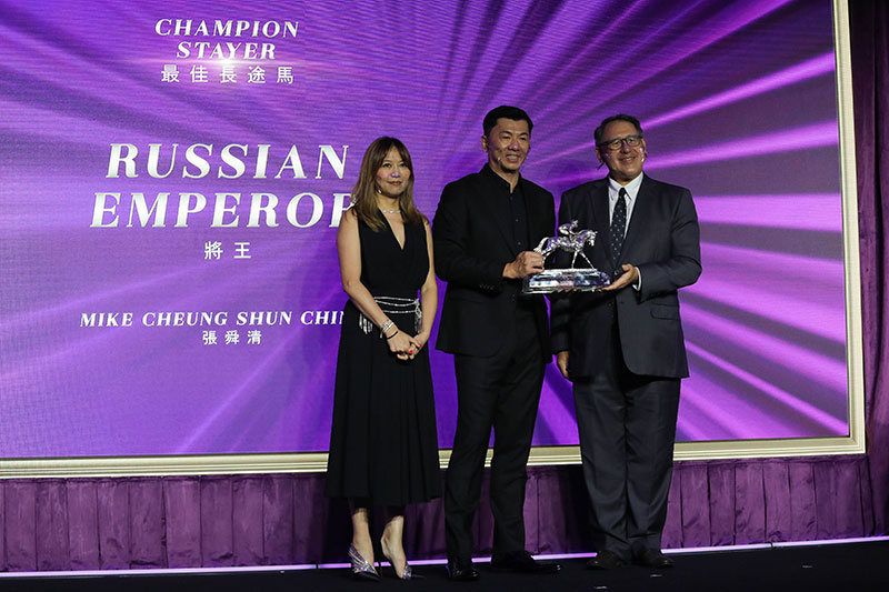 Mr Lester Huang, Steward of The Hong Kong Jockey Club, presents the Champion Stayer trophy to Mr Mike Cheung Shun Ching, owner of Russian Emperor, accompanied by his wife.