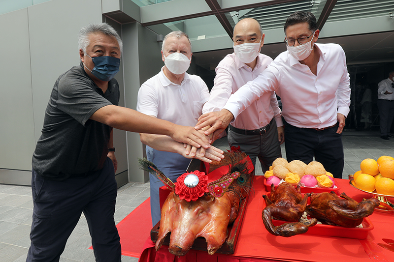 Senior Club officials carve the roasted pigs at the bai-sun ceremony.