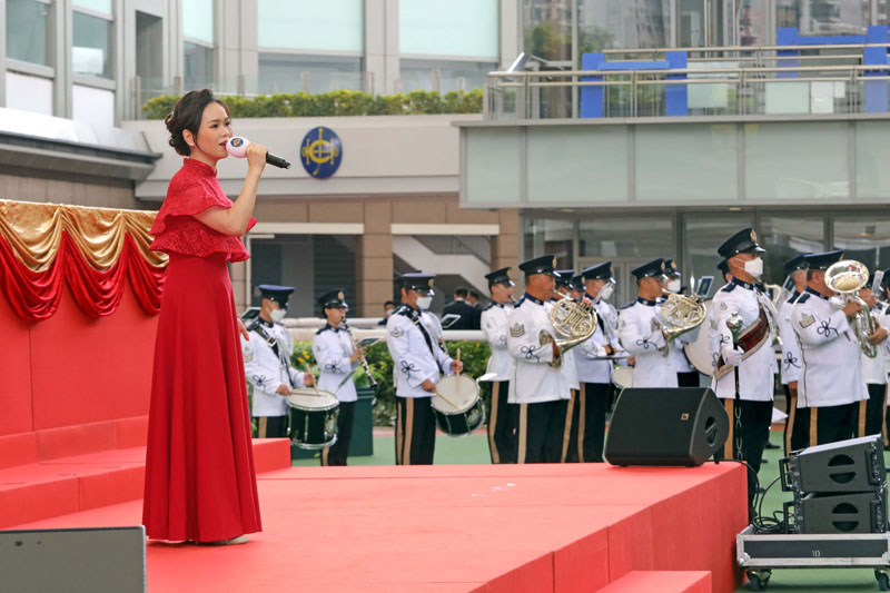 Ms Phoebe Tam Lok Hin, Hong Kong Soprano, leads the singing of the National Anthem, accompanied by the Hong Kong Police Band.