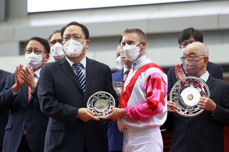 Winning Trainer David Hayes and Jockey Zac Purton receive silver dishes from Mr Pan Yundong, Deputy Commissioner of Office of the Commissioner of the Ministry of Foreign Affairs of the People’s Republic of China in the HKSAR.
