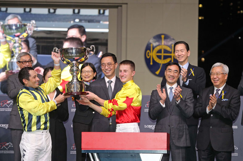 香港特別行政區政府文化體育及旅遊局局長楊潤雄先生GBS JP頒發獎盃予浪琴國際騎師錦標賽平頭冠軍蘇兆輝及馬昆。