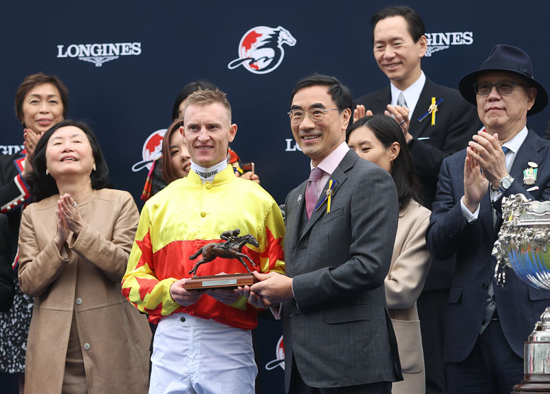 香港賽馬會主席利子厚先生頒發浪琴香港一哩錦標獎盃及騎師駿馬銅像予「加州星球」的馬主梁欽聖、練馬師告東尼及騎師潘頓。