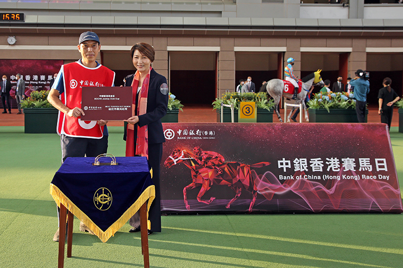 Before the race, Macy Ng, Deputy General Manager of Personal Banking and Wealth Management Department, Bank of China (Hong Kong) Limited, presents a prize at the parade ring to the stable assistant responsible for Beauty Joy, the best turned out horse for the BOCHK Jockey Club Cup.