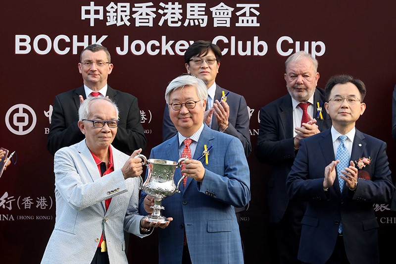 HKJC Steward Dr Silas Yang presents the BOCHK Jockey Club Cup trophy and silver dishes to Romantic Warrior’s owner Peter Lau, trainer Danny Shum and jockey James McDonald.