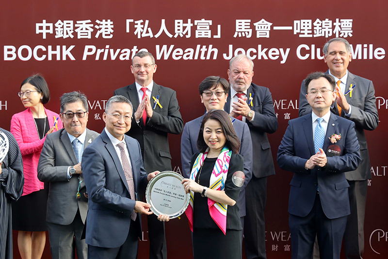 Mary Lo, General Manager of Personal Digital Banking Product Department, Bank of China (Hong Kong) Limited, presents a silver dish to winning trainer Francis Lui.