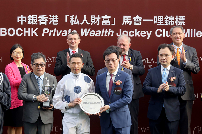 Huang Jinyue, General Manager of BOC Credit Card (International) Limited, presents a silver dish to winning jockey Vincent Ho.