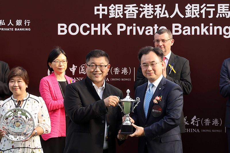 中國銀行（香港）有限公司副總裁陳文致送紀念品予「金鑽貴人」的馬主鄭明亮。