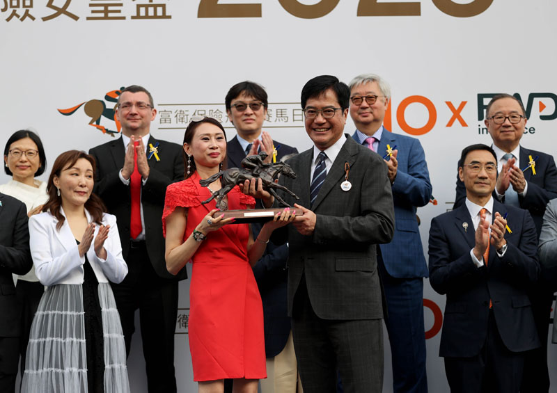 The Honourable Michael Wong Wai-lun GBS JP, Deputy Financial Secretary of the Government of the Hong Kong Special Administrative Region presents the FWD QEII Cup and bronze statuettes of a horse and jockey to Romantic Warrior’s Owner Peter Lau Pak-fai and owner’s representative, trainer Danny Shum and jockey James McDonald.