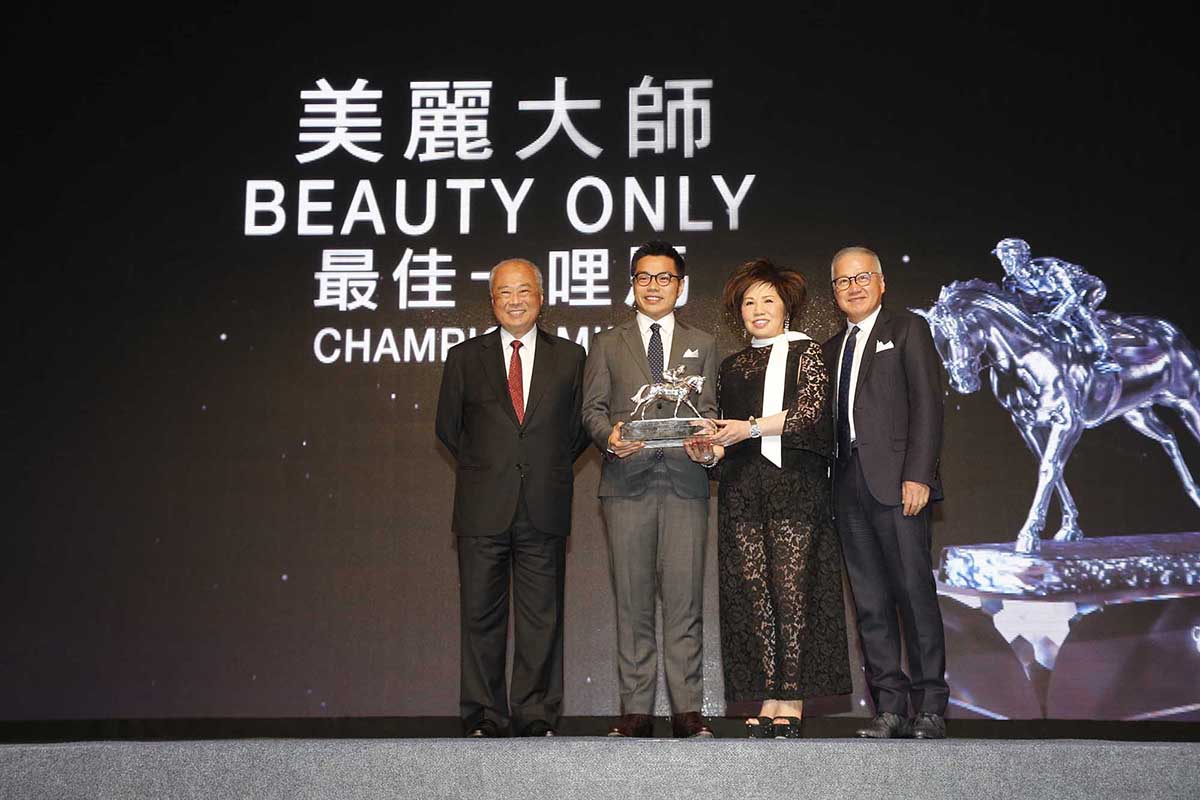 馬會董事周松崗爵士頒發最佳一哩馬獎座予「美麗大師」的馬主郭羅桂珍女士與郭浩泉先生(中)，並由郭少明先生(右)陪同。