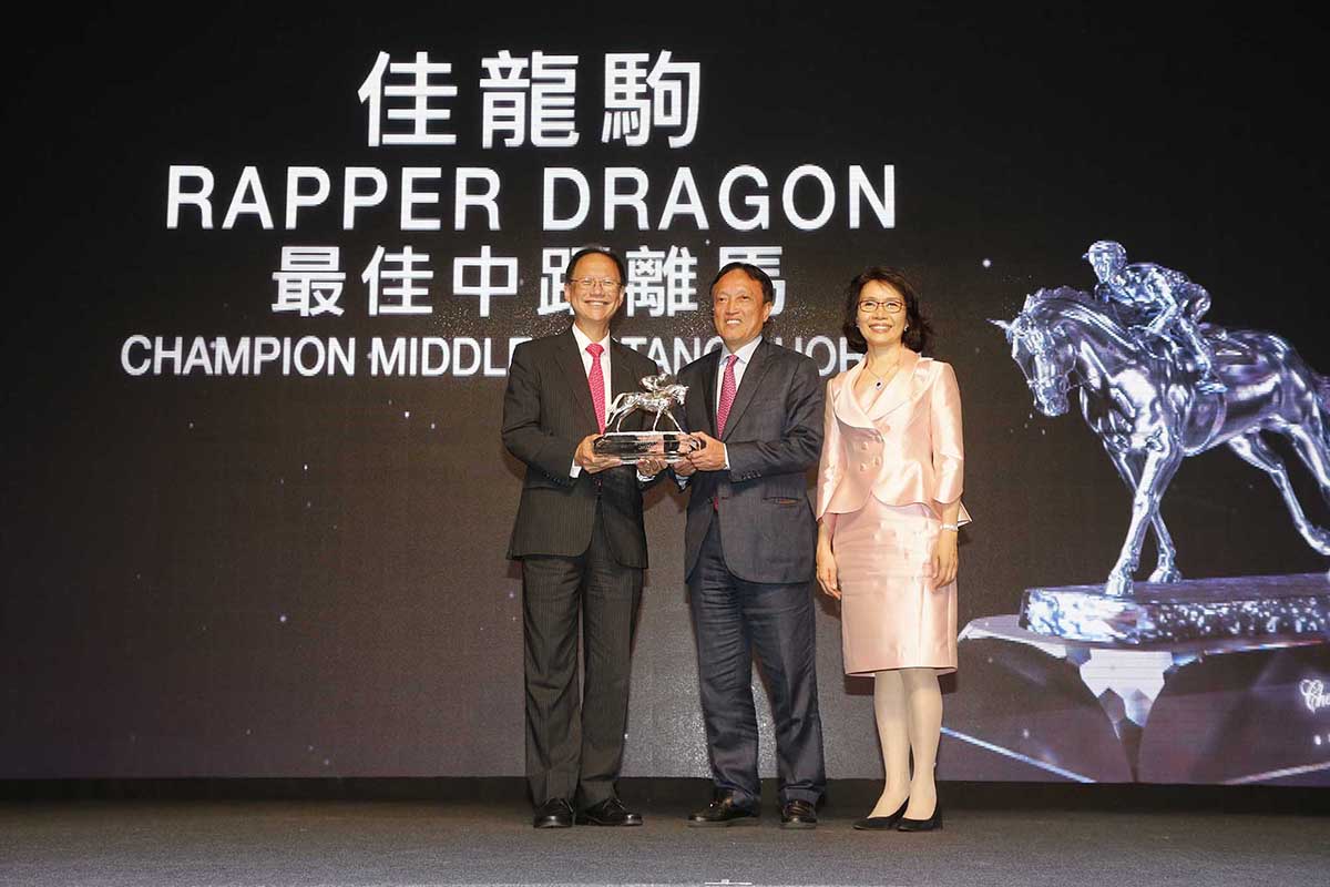 馬會董事陳南祿先生頒發最佳中距離馬獎座予「佳龍駒」的馬主洪祖杭先生及夫人。