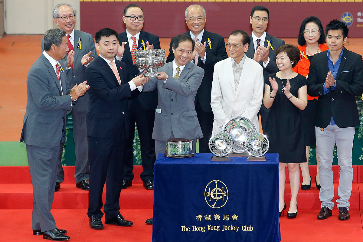 中央人民政府駐香港特別行政區聯絡辦公室宣傳文體部部長朱文（左），將國慶盃的獎盃頒發予勝出馬匹「飛來猛」的馬主代表。
