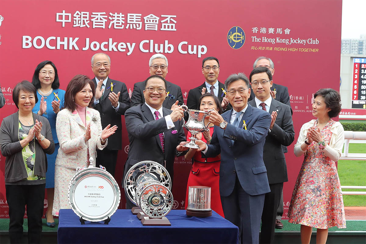 馬會董事鄭維志博士於頒獎禮上將中銀香港馬會盃獎盃及銀碟頒予「明月千里」的馬主程凱信、練馬師約翰摩亞及騎師貝湯美。
