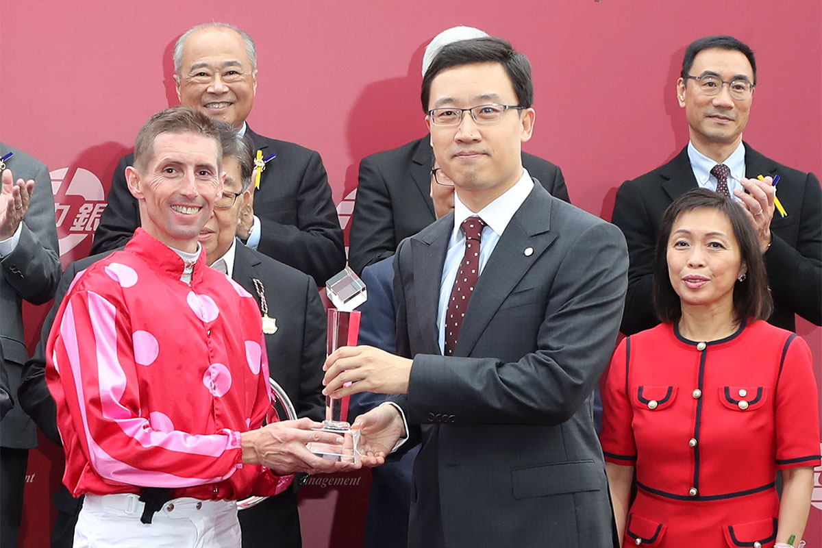中國銀行（香港）有限公司個人金融及財富管理總經理孫大威（右）頒發水晶獎座予騎師羅理雅。
