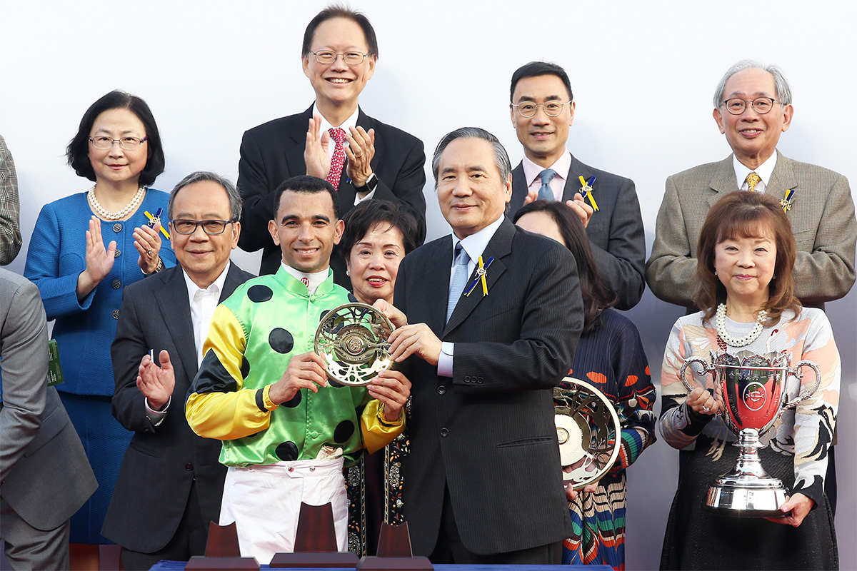 馬會董事葉澍堃於頒獎禮上將香港經典一哩賽冠軍獎盃及鍍金碟頒予「當家精選」的馬主幸運角團體的代表、練馬師蔡約翰及騎師莫雷拉。