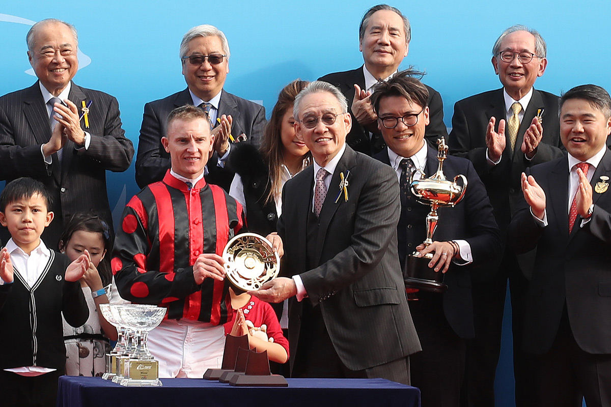 馬會副主席周永健（右）頒發花旗銀行香港金盃獎盃及鍍金碟予頭馬「馬克羅斯」的馬主蕭劍新 、練馬師告東尼及騎師潘頓 。