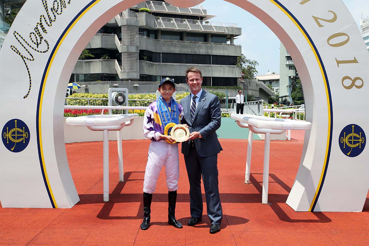 香港賽馬會賽馬事務執行總監夏定安於畢業禮上，頒發紀念銀碟予黃皓楠。