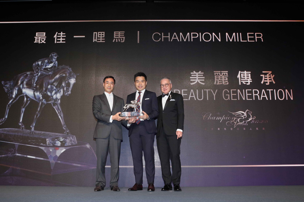 馬會董事利子厚先生頒發最佳一哩馬獎座予「美麗傳承」的馬主郭浩泉先生，並由郭少明博士陪同上台領獎。