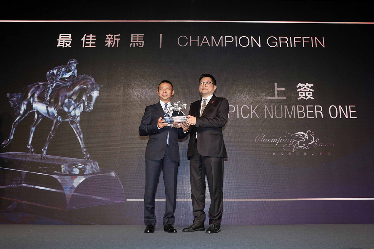 香港評馬同業協進會主席吳伽樂先生頒發最佳新馬獎座予「上簽」的練馬師沈集成，他代表馬主余慕文先生領獎。