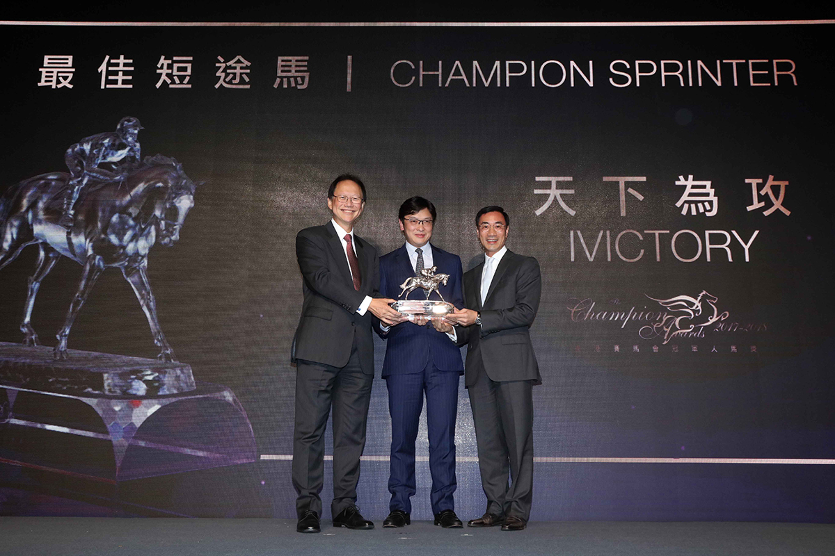 馬會董事陳南祿先生頒發最佳短途馬獎座予「天下為攻」的馬主利子厚先生與陳衍里醫生。