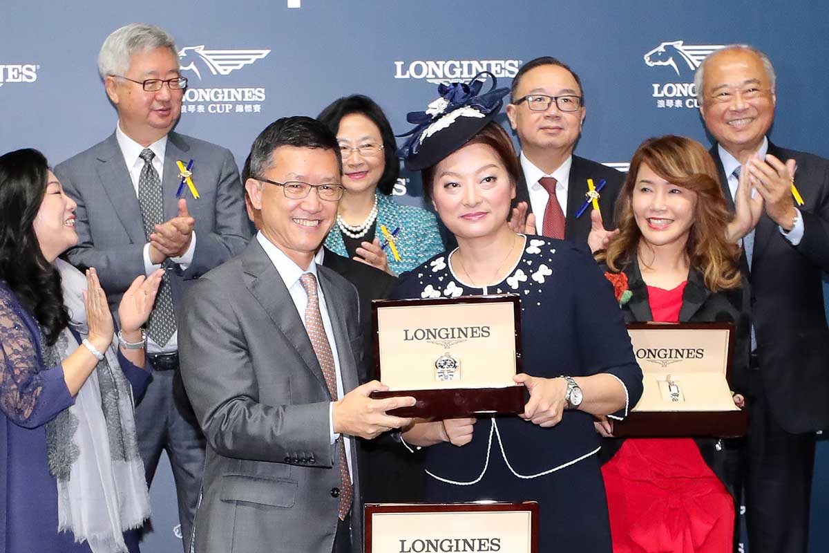 LONGINES香港區副總裁歐陽楚英小姐將LONGINES康卡斯系列腕表頒發予勝出馬匹「驫驫」的馬主葉俊亨先生及夫人 、練馬師何良及騎師潘明輝。