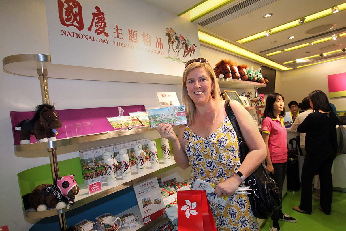入場人士選購一系列以國慶賽馬日為主題的精品，包括香港賽馬會與香港郵政合作發行的國慶賽馬日紀念封。