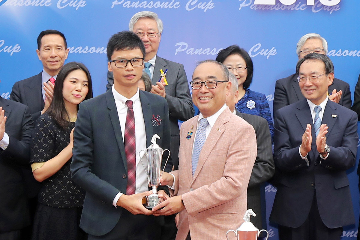 信興集團主席兼行政總裁蒙德揚（右）頒發獎盃予「大籐王」的助理練馬師馬譜鐘。