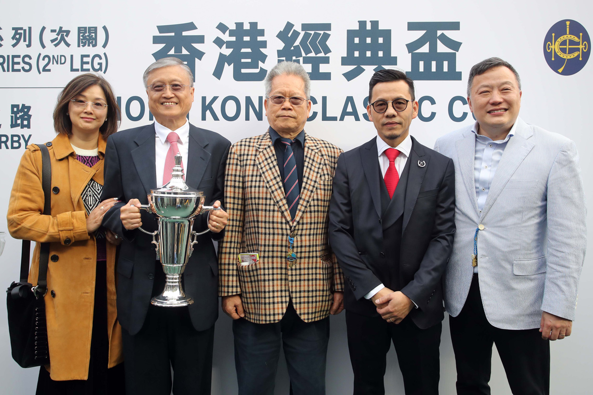 香港經典盃勝出馬匹「妙算達人」的練馬師羅富全賽後與馬主小資風雅團體代表合照慶祝勝利。