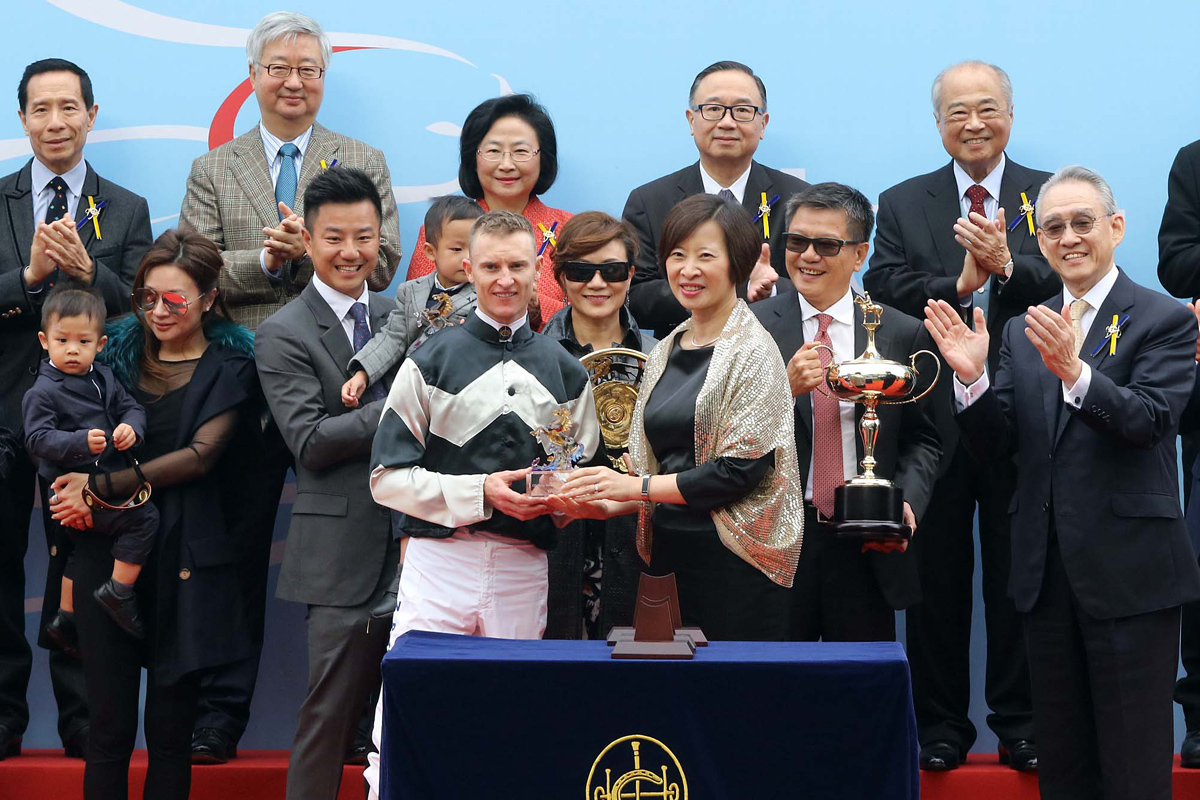 花旗集團香港及澳門區行長伍燕儀（右）致送紀念品予頭馬「時時精綵」的馬主代表、練馬師告東尼及騎師潘頓。