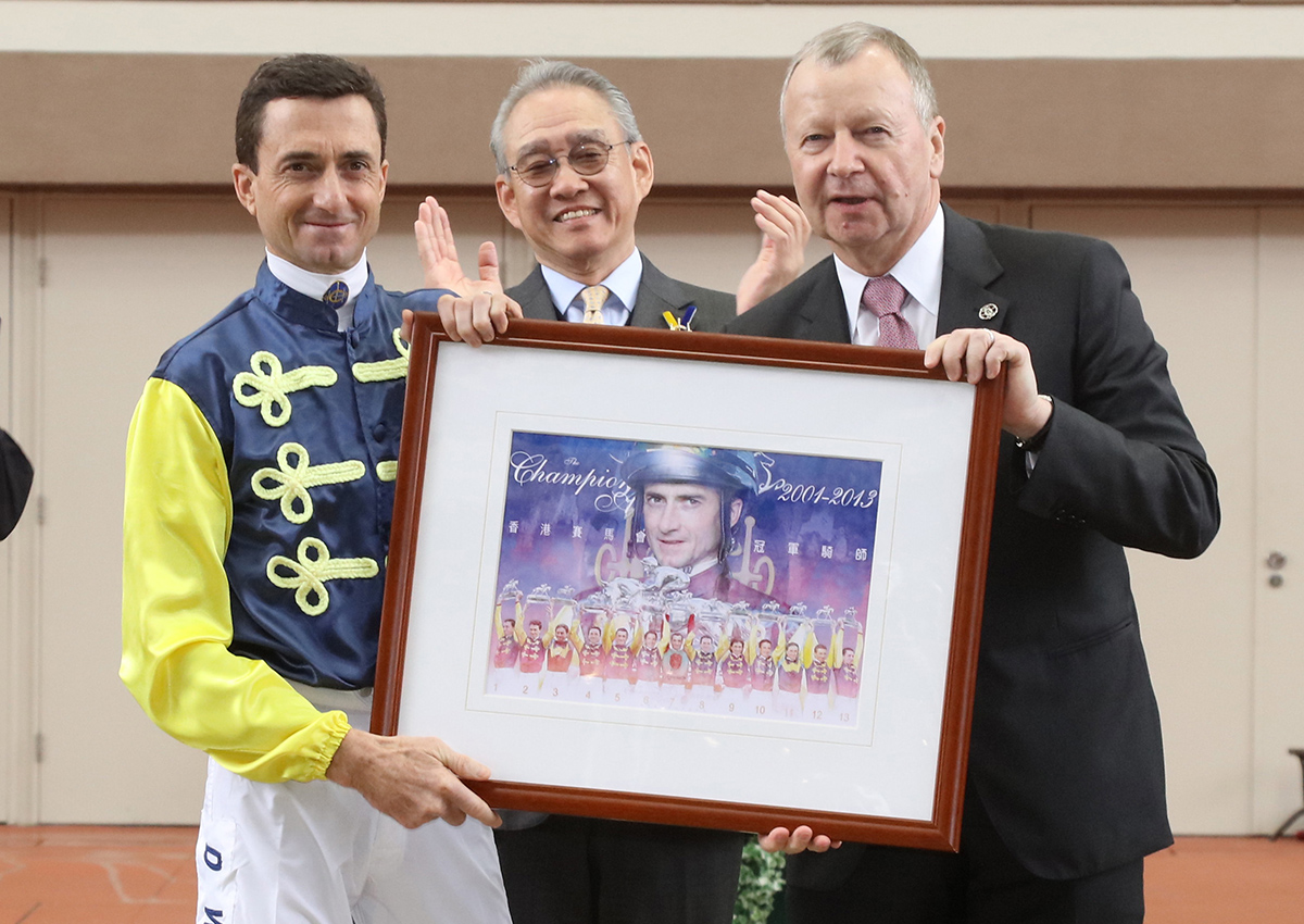 香港賽馬會行政總裁應家柏向韋達頒贈一幅畫作。
