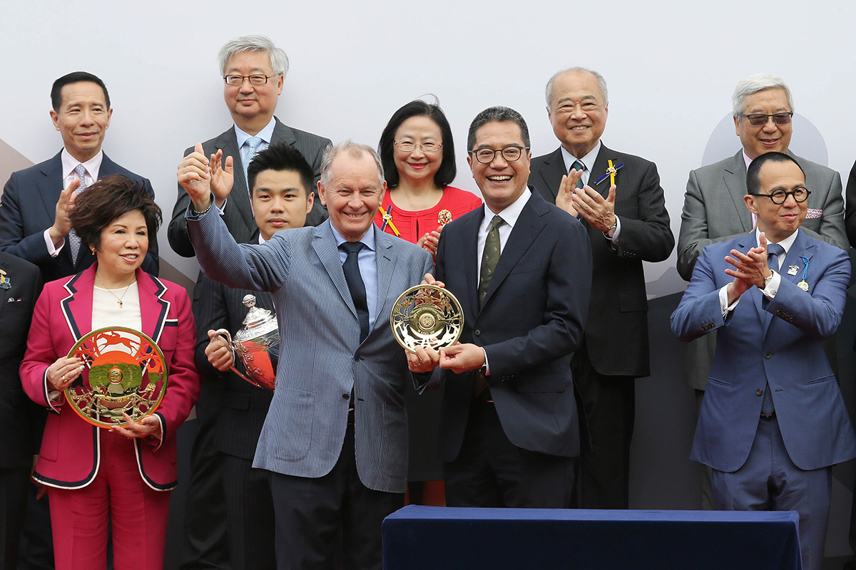 香港特別行政區政府發展局局長黃偉綸先生JP頒發鍍金碟予「美麗傳承」的馬主代表郭羅桂珍、勝出練馬師約翰摩亞及勝出騎師潘頓。