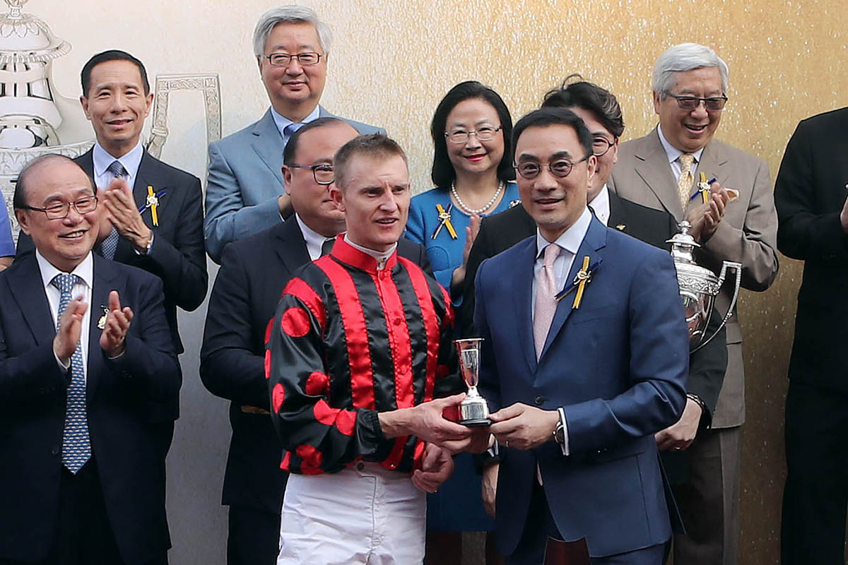 香港賽馬會董事利子厚（右）於頒獎禮上頒發港澳盃及冠軍銀碟予頭馬「信心保證」的馬主蕭劍新、練馬師約翰摩亞及騎師潘頓。