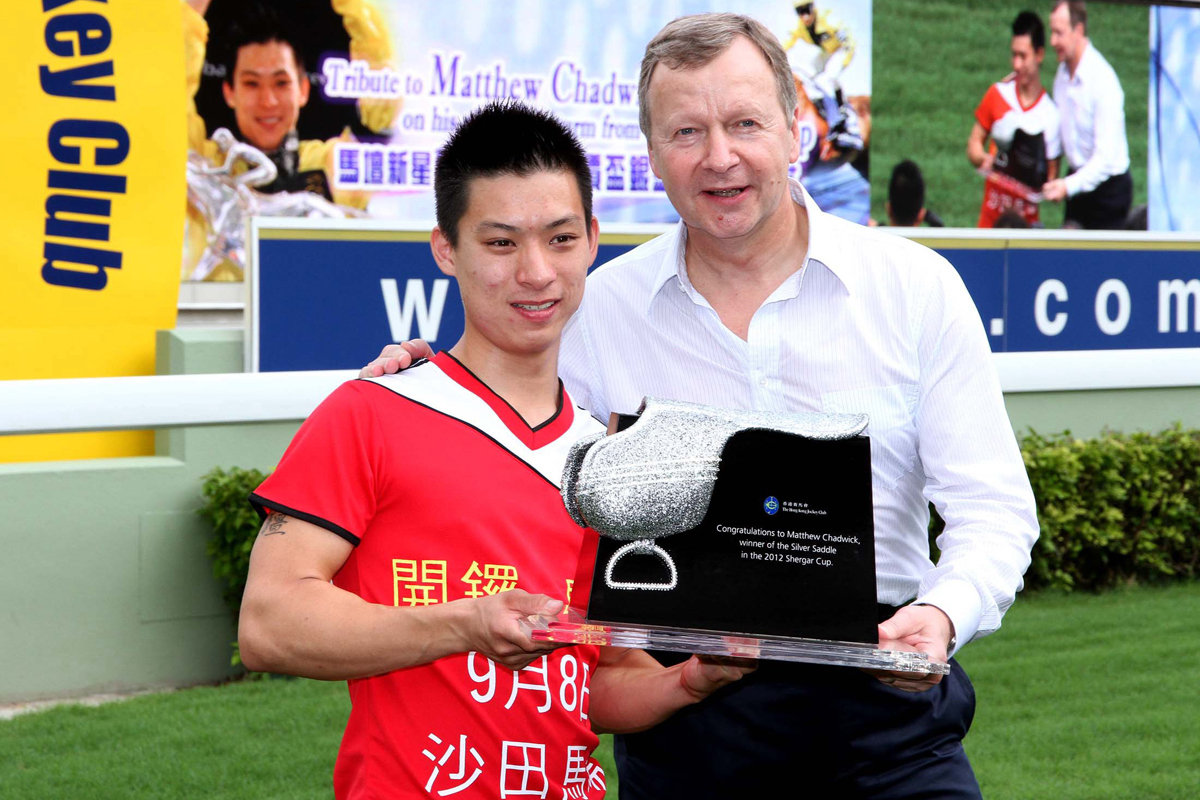 馬會行政總裁應家柏在2012年季前嘉年華會中頒發馬會特別訂製的銀馬鞍獎座予蔡明紹。