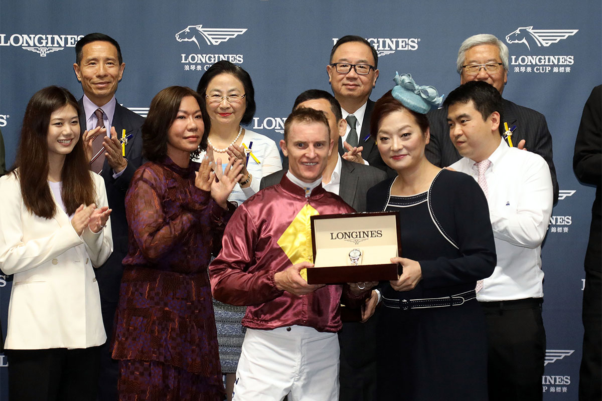 LONGINES香港區副總裁歐陽楚英小姐將LONGINES索伊米亞系列腕表頒發予勝出馬匹「快樂歡騰」的馬主張順宜先生、練馬師蘇偉賢及騎師潘頓。