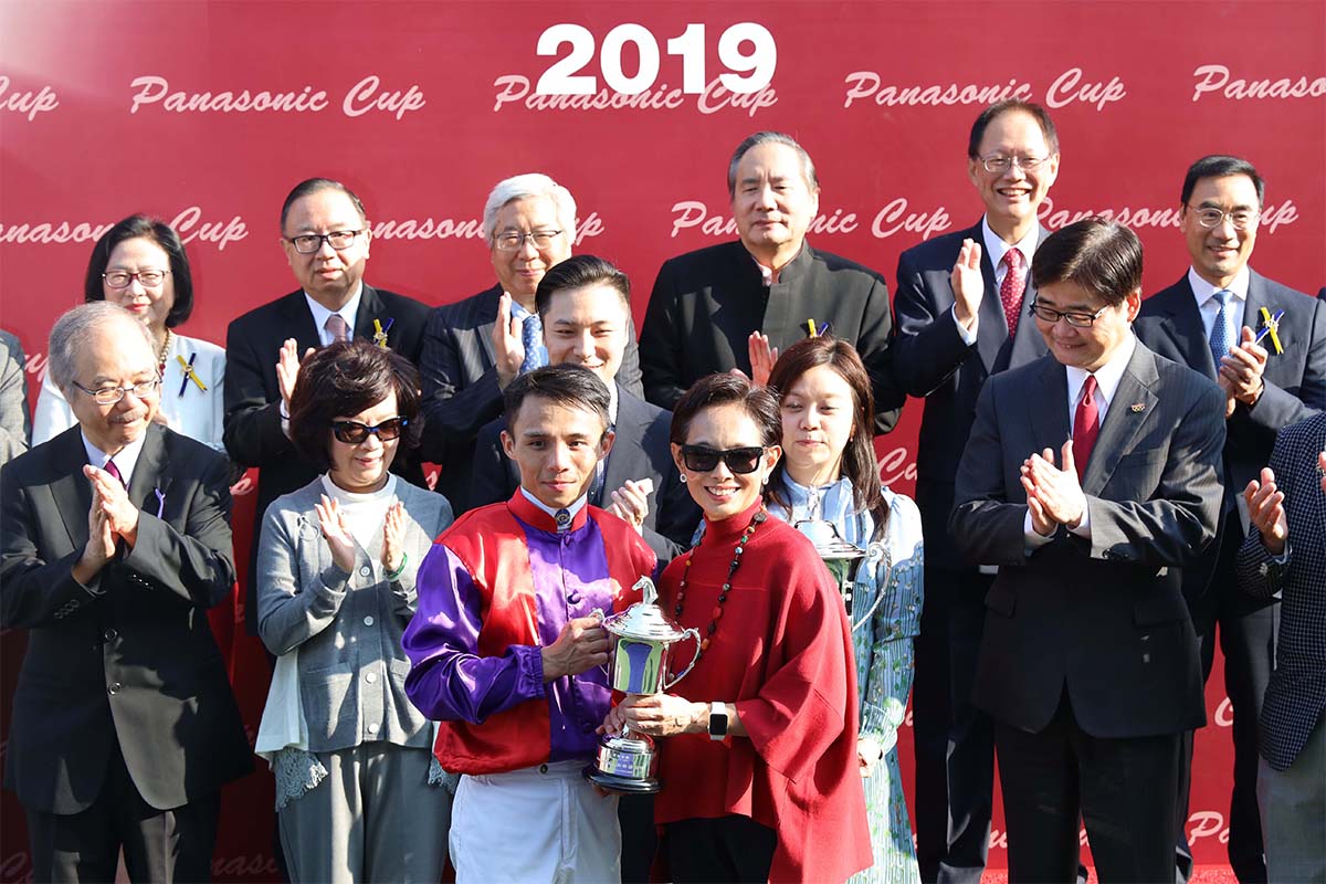 信興電器貿易有限公司執行董事蒙倩兒（右）頒發獎盃予「安騏」的騎師陳嘉熙。