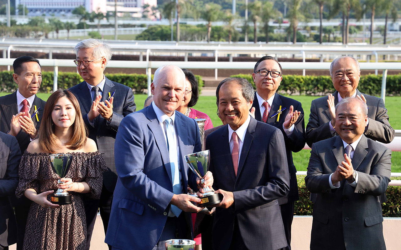 其士國際集團有限公司副董事總經理譚國榮先生頒發獎盃予「百步穿雲」的練馬師賀賢 。