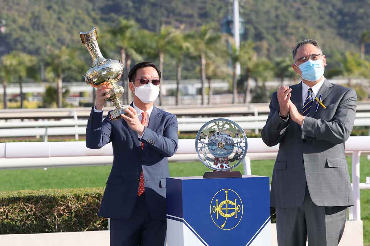 馬會董事黃嘉純（右）頒發百週年紀念銀瓶獎盃及銀碟予「龍鼓飛揚」金玉滿堂團體代表。