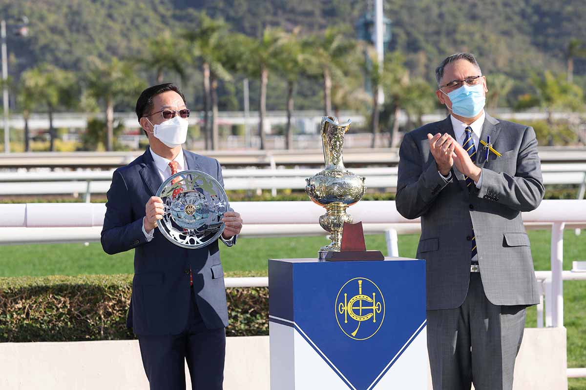馬會董事黃嘉純（右）頒發百週年紀念銀瓶獎盃及銀碟予「龍鼓飛揚」金玉滿堂團體代表。