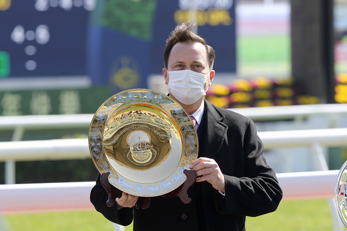 「帖木兒」的馬主代表方嘉柏展示洋紫荊短途錦標獎盃。