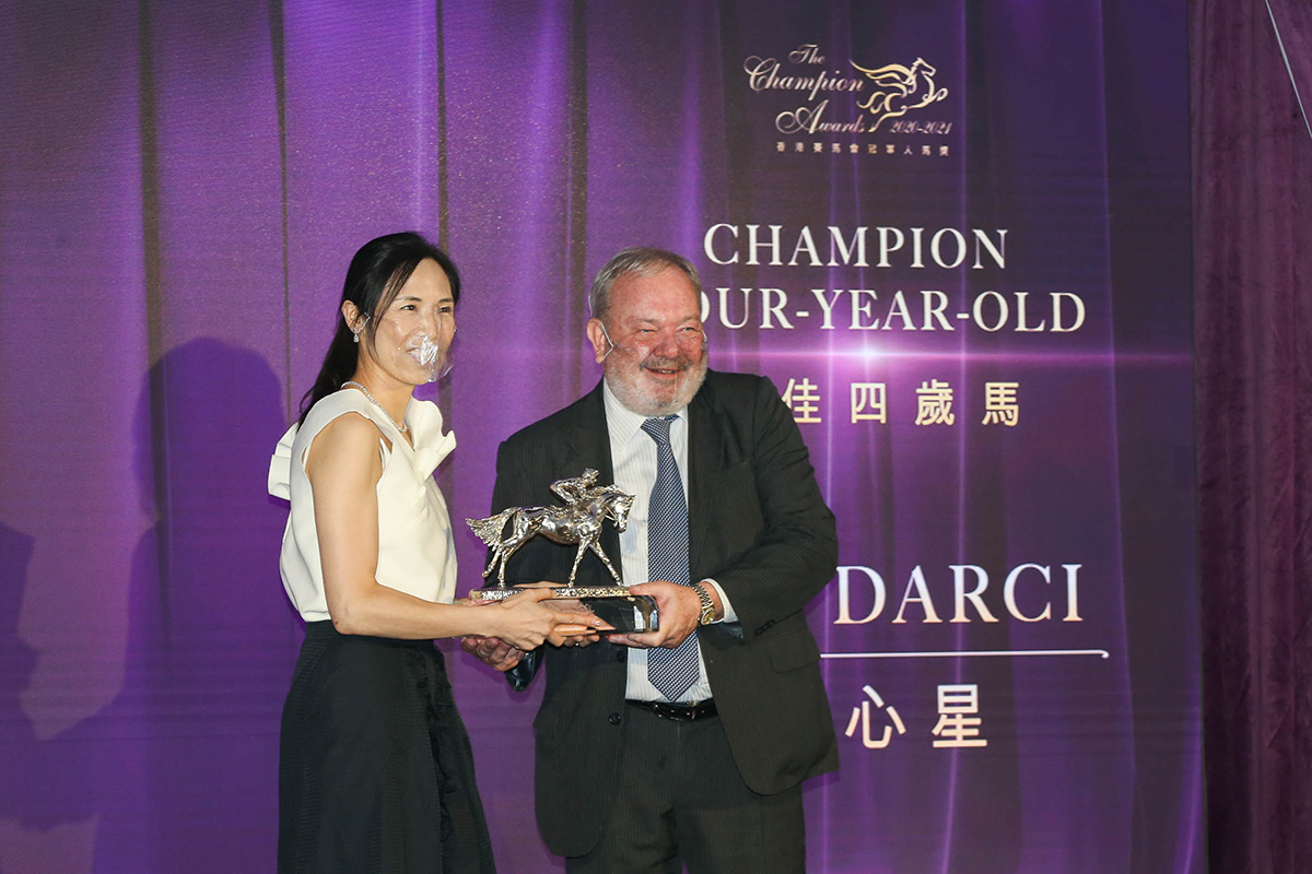 香港賽馬會董事孔思和先生頒發最佳四歲馬獎座予「達心星」的馬主關敏恒女士。