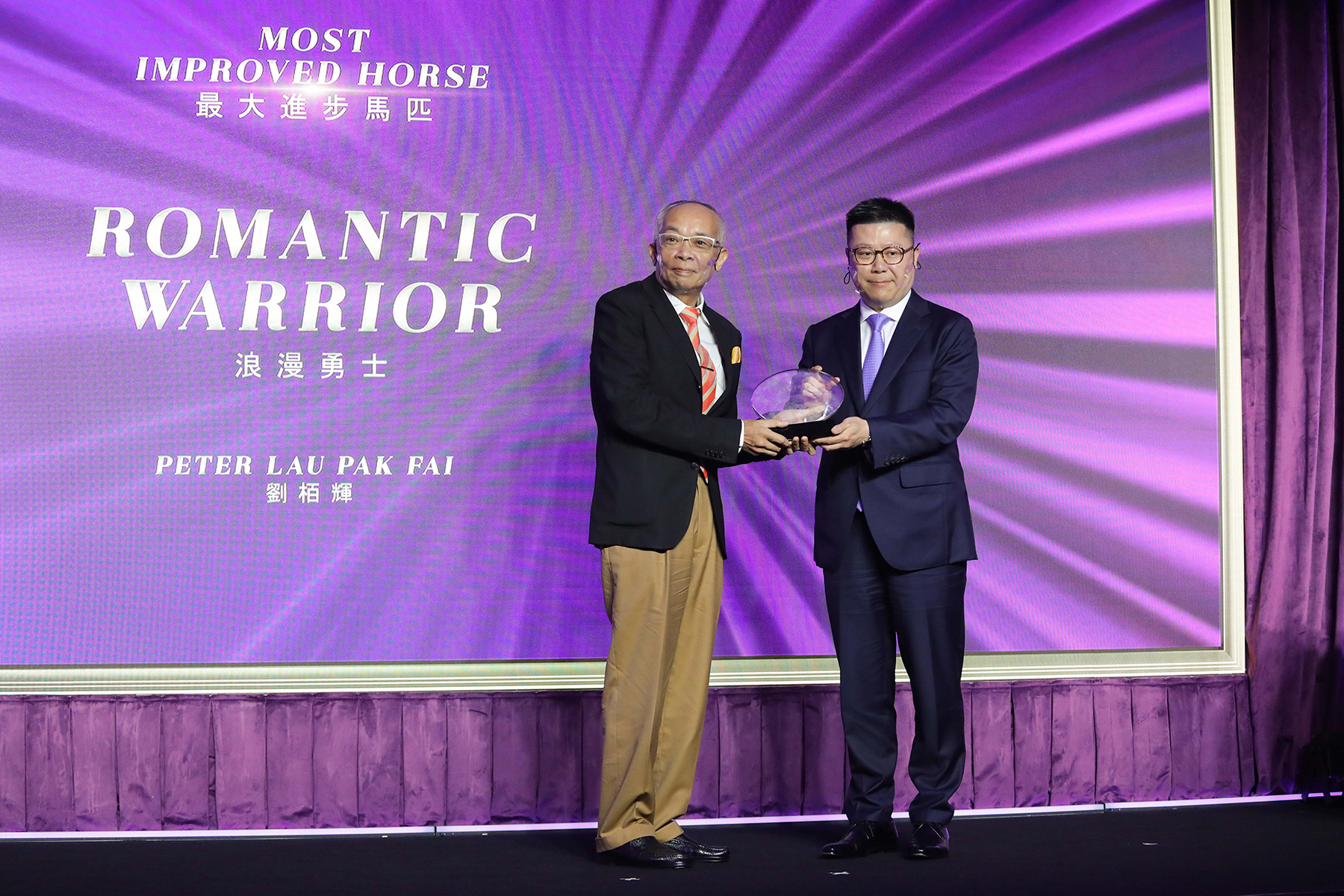 香港馬主協會會長林建康先生頒發最大進步馬匹獎座予「浪漫勇士」的馬主劉栢輝先生。