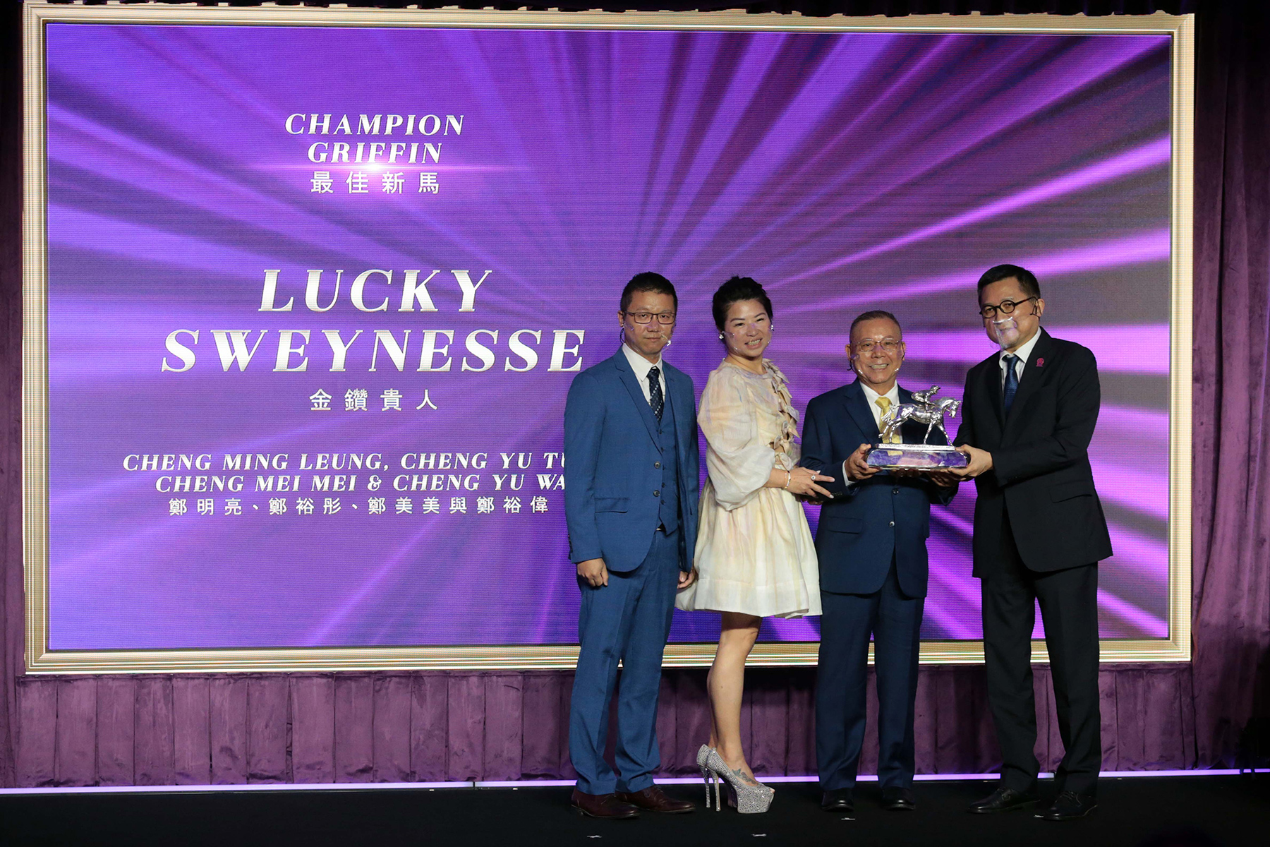 香港評馬同業協進會主席吳伽樂先生頒發最佳新馬獎座予「金鑽貴人」的馬主鄭明亮先生、鄭裕彤夫人與鄭裕偉先生。