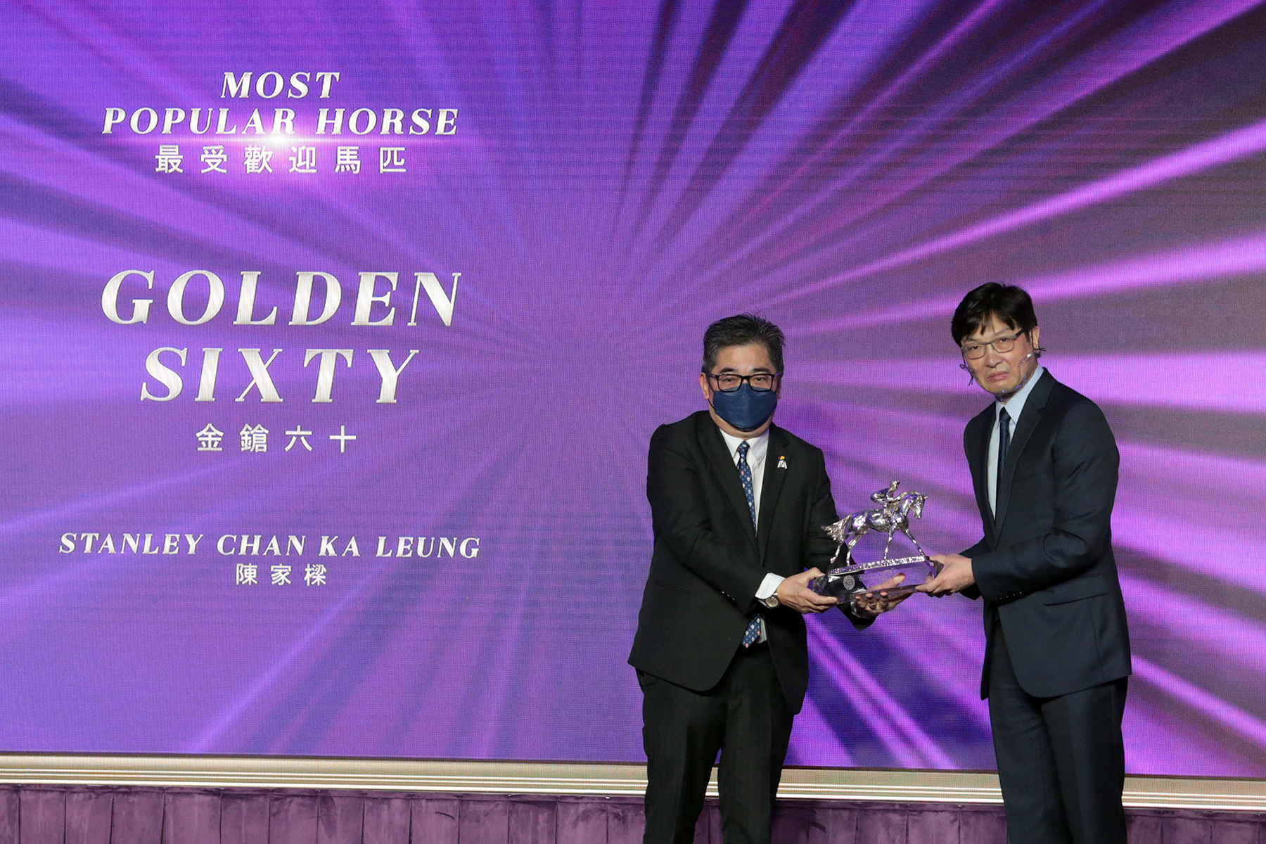 香港賽馬會董事陳衍里醫生頒發最受歡迎馬匹獎座予「金鎗六十」的馬主陳家樑先生。