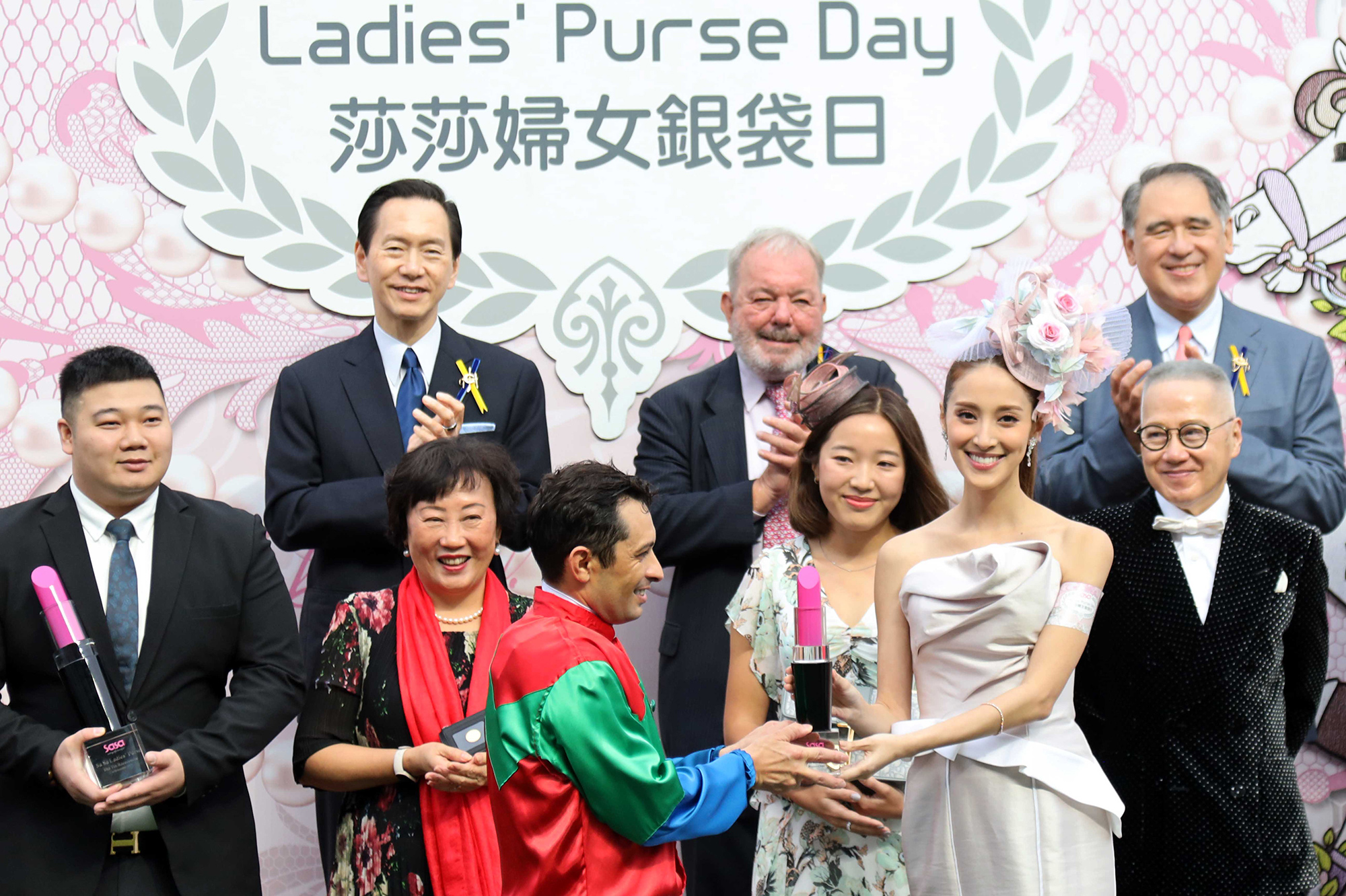 莎莎婦女銀袋日形象大使陳凱琳小姐在莎莎婦女銀袋頒獎儀式上，致送紀念盃予冠軍馬匹「發財先鋒」的騎師蘇兆輝。